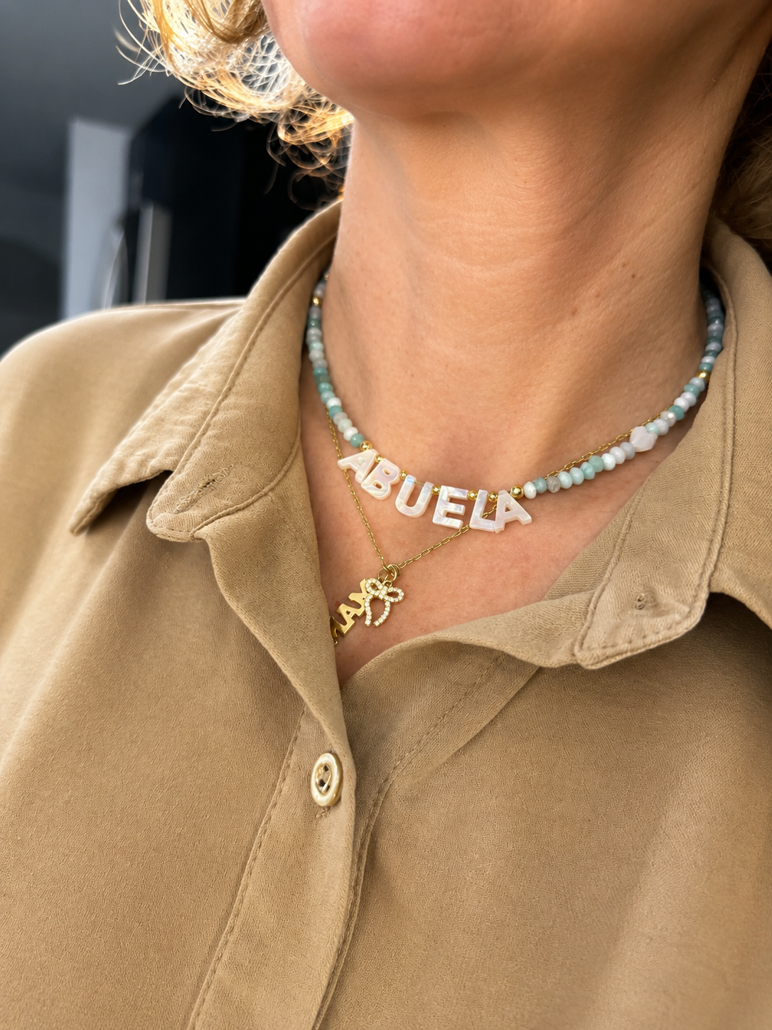 Woman wearing a short Necklace with 'ABUELA' letters
