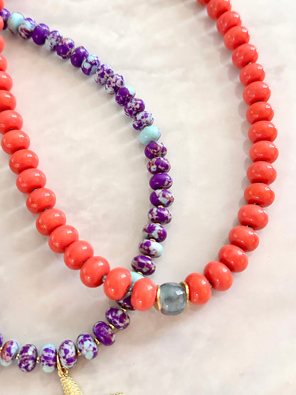 Close up of Necklace with coral beads and a single marble gemstone centerpiece 