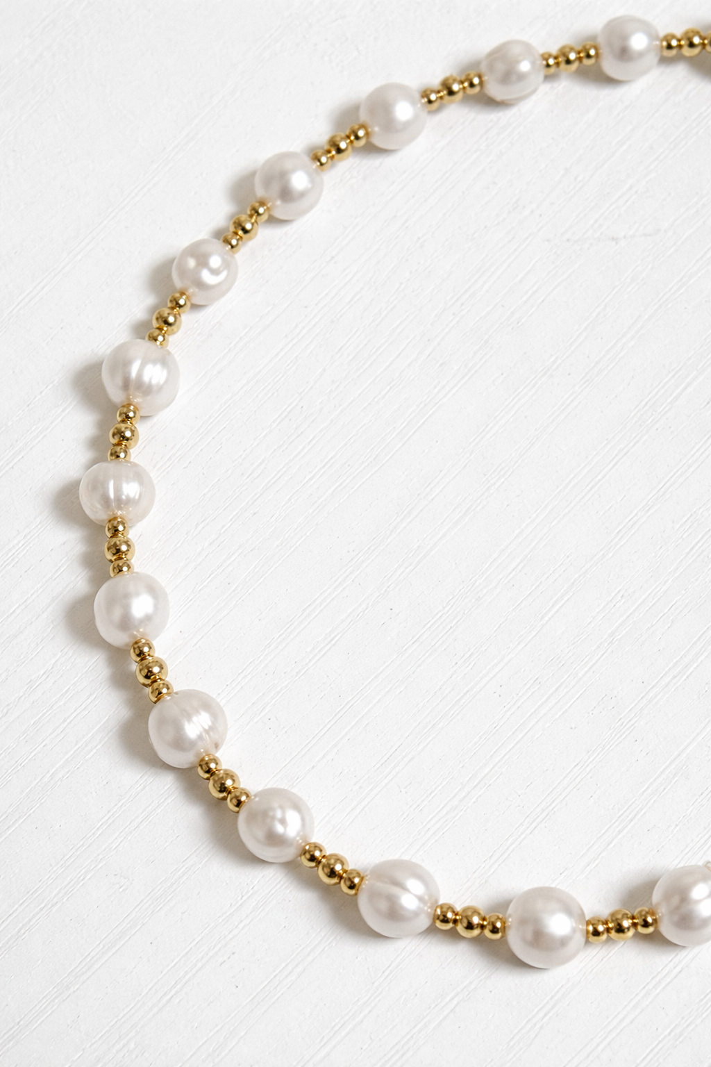 Minimal pearl necklace flat lay gold beads