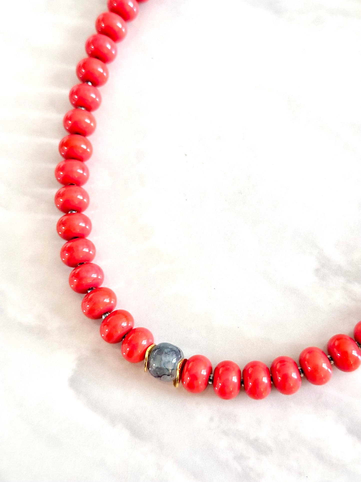 Necklace with coral beads and a single marble gemstone centerpiece 