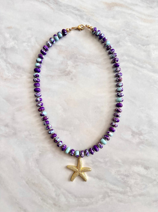 Necklace with purple beads and a gold starfish pendant 