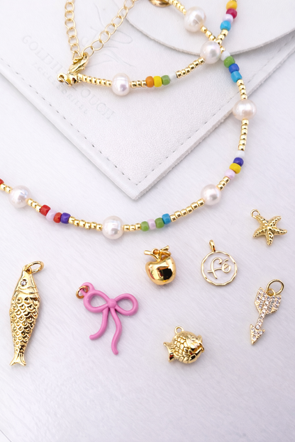 colorful beaded necklace, charms, and a white envelope on a light background