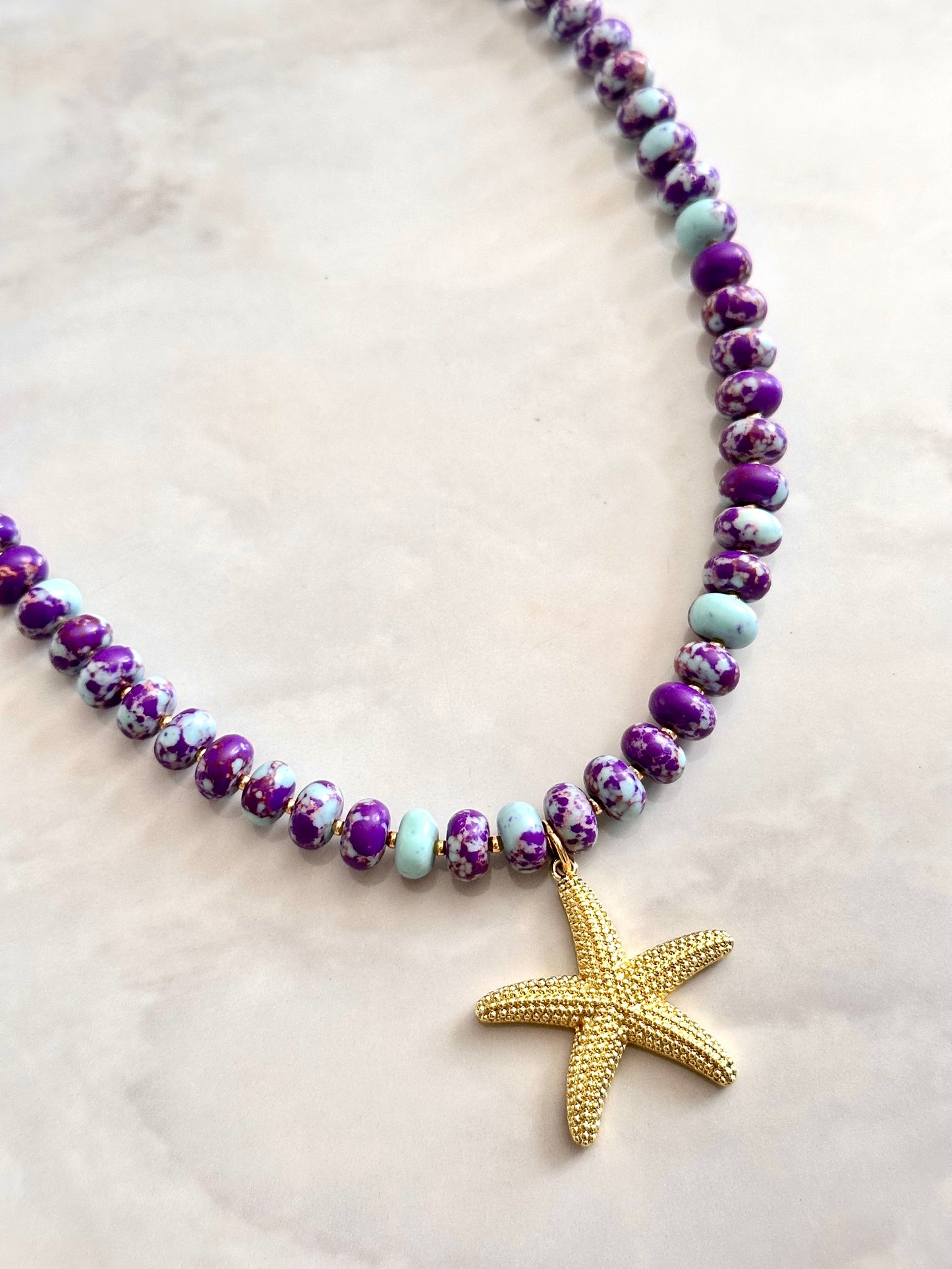 Beaded necklace with a starfish pendant on a light background