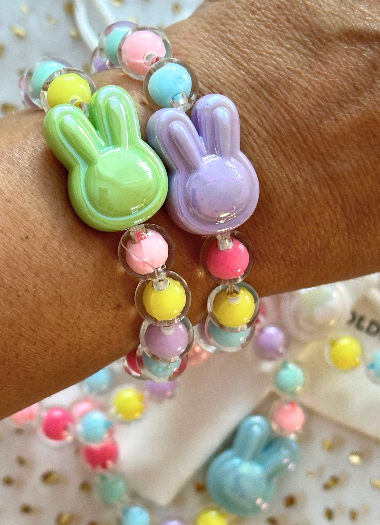 Colorful bunny-shaped bracelet on a wrist with a blurred background